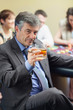 Man with cigar raising whiskey glass at roulette table