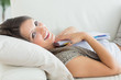Woman clutching notepad lying on the sofa
