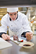 Chef putting berry coulis on the dessert