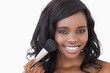 Smiling woman using makeup brush