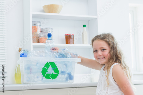 Photo: Girl sorting plastics into crates Girl sorting plastics into crates