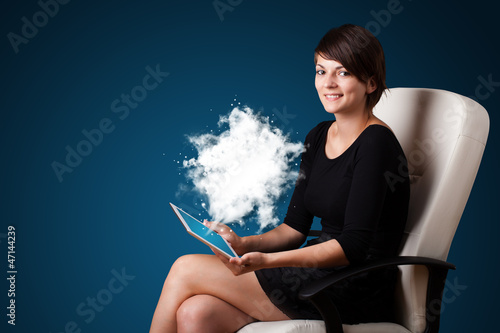 Photo: Young woman looking at modern tablet with abstract cloud Young woman looking at modern tablet with abstract cloud