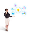 Young woman presenting light bulb with colorful graphs and diagr