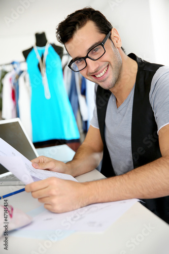 Photo: Smiling fashion designer in workshop Smiling fashion designer in workshop