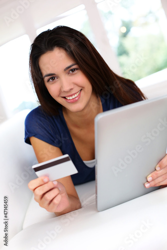 Photo: Brunette girl doing online shopping with digital tablet Brunette girl doing online shopping with digital tablet