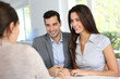 Young couple signing financial contract