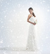A young bride in a white dress on a snowy background