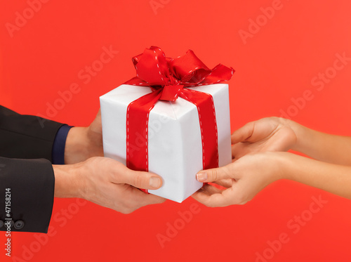 Photo: man and woman's hands with gift box man and woman's hands with gift box
