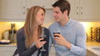 Couple sitting in the kitchen drinking wine