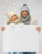 couple in a winter clothes holding blank board