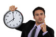 Stern businessman with a clock