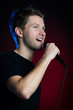 junger mann singt mit mikrofon