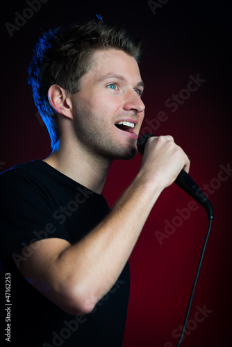 Photo: junger mann singt mit mikrofon junger mann singt mit mikrofon
