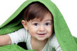 Happy baby covered with a green towel