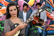 Female guitarist standing with band members