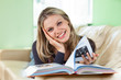 Photo: Pretty Young Woman Lying on a Couch Reading a Book Pretty Young Woman Lying on a Couch Reading a Book