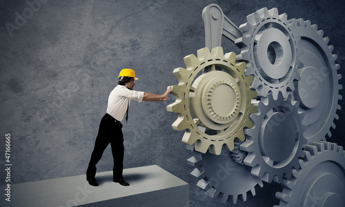 Photo: Businessman turning a gear system Businessman turning a gear system