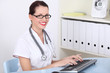 Photo: Female doctor working on pc computer Female doctor working on pc computer