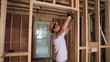 Builder hammering door frame
