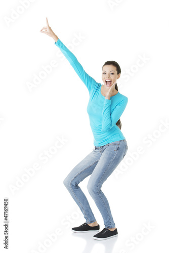 Photo: Excited young woman pointing on copy space Excited young woman pointing on copy space