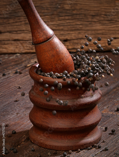 Photo: Grinding black pepper with a mortar and pestle Grinding black pepper with a mortar and pestle