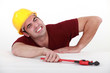 Workman with a wrench in a tight spot