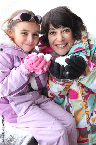 Photo: Mother and daughter playing together in the snow Mother and daughter playing together in the snow