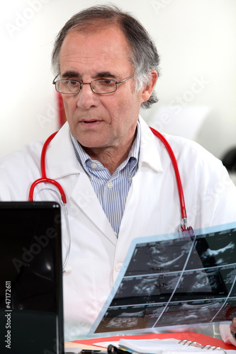Photo: Male doctor examining x-ray Male doctor examining x-ray