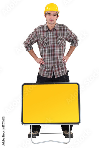 Photo: Worker stood by blank road sign Worker stood by blank road sign