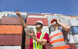 two workers with tablet pc and standing before stack of containe