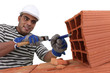 bricklayer at work with red bricks indoors