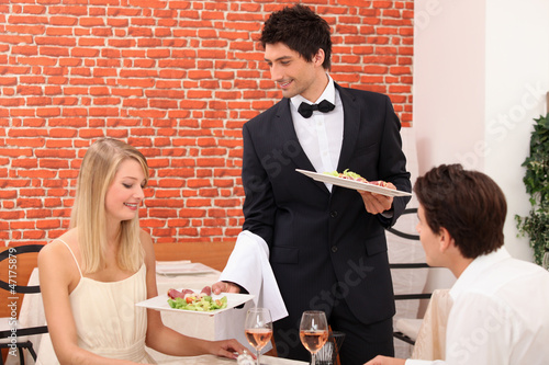 Photo: Waiter serving plate of food Waiter serving plate of food