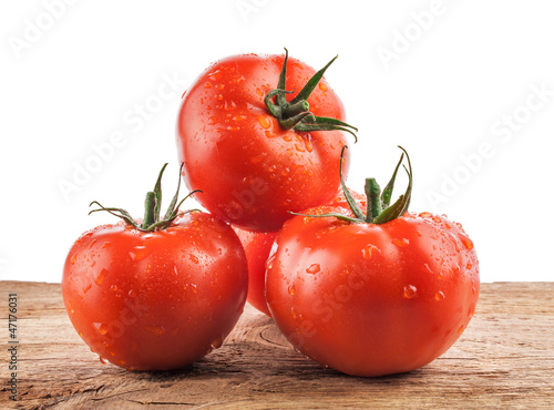 Photo: Collection of Tomatoes on the old wooden board with water drops Collection of Tomatoes on the old wooden board with water drops