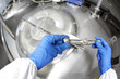 hands in blue Glover closing industrial process tank