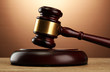 wooden gavel on wooden table, on brown background