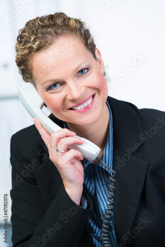 Photo: beraterin am telefon mit einem freundlichem lächeln beraterin am telefon mit einem freundlichem lächeln