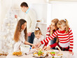 Family with children rolling dough in Xmas kitchen.