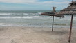 Storm the Mediterranean Sea and palm-leaf parasols on the beach