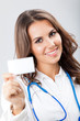 Young female doctor showing blank business card
