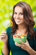 Young woman with salad, outdoors