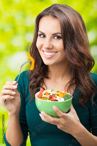 Photo: Young woman with salad, outdoors Young woman with salad, outdoors