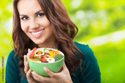 Photo: Young woman with salad, outdoors Young woman with salad, outdoors