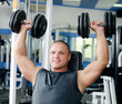 Foto: Man with dumbbells in sports club Man with dumbbells in sports club