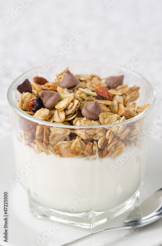 Photo: yogurt and granola with chocolate drops in a glass beaker yogurt and granola with chocolate drops in a glass beaker