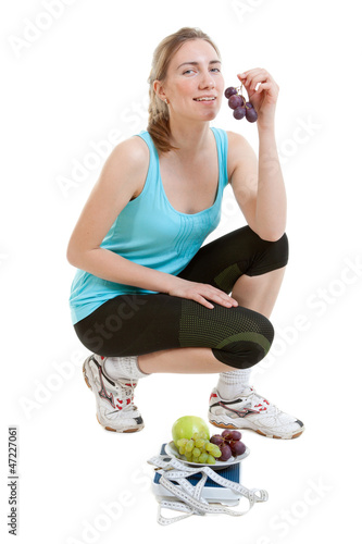 Photo: Sporty young woman with scales and fruits. healthy lifestyle Sporty young woman with scales and fruits. healthy lifestyle