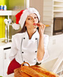 Female chef in Santa hat  holding  food.