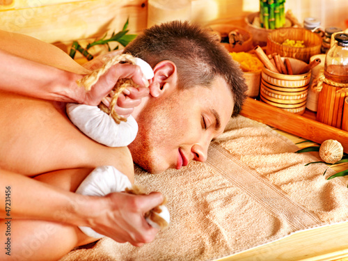 Photo: Man getting herbal ball massage treatments . Man getting herbal ball massage treatments .