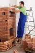 Worker building masonry heater