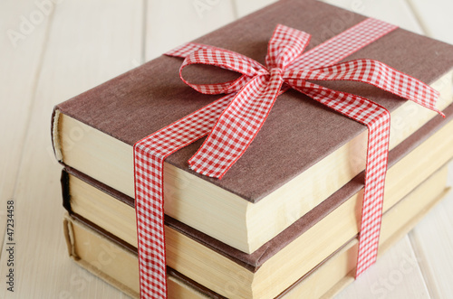 Photo: Books bounded up in red ribbon Books bounded up in red ribbon