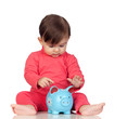 Adorable baby girl sitting with a blue piggy-bank